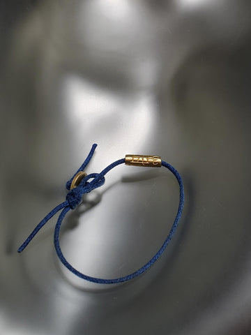 18K Gold "Om" Tube On Blue Cord Baby Bracelet